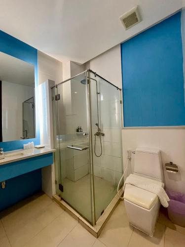 a bathroom with a glass shower and a toilet at Korapura Resort in Nakhon Ratchasima