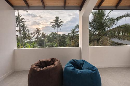 two chairs sitting in a room with a large window at Paragon Villa Madiha in Matara