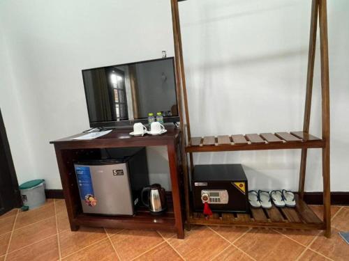 two wooden shelves with a microwave and a tv at Win Hotel Vang Vieng in Vang Vieng