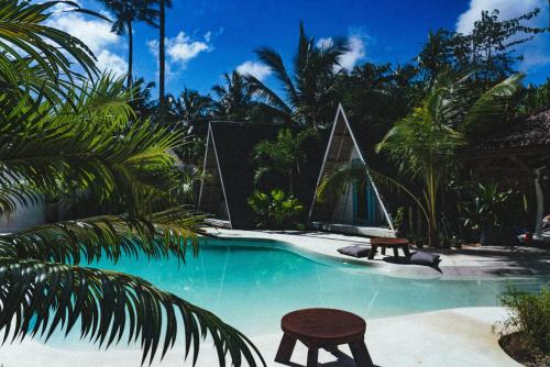 a swimming pool with two chairs and a table at Mao Mao surf in General Luna