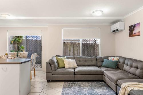 a living room with a couch and a kitchen at Sunshine Hideaway - Easy Beachside Living in Mooloolaba
