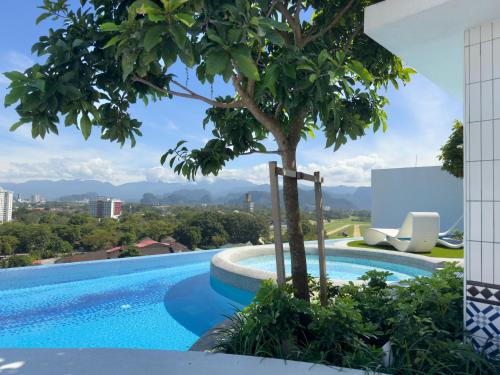 a view of a swimming pool with a tree at Stallionz by KLIQ in Ipoh