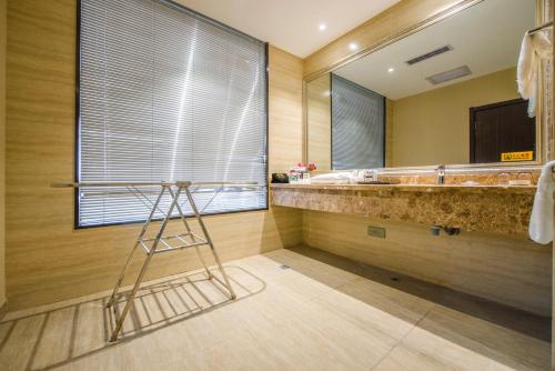 ein Badezimmer mit einem großen Waschbecken und einem Spiegel in der Unterkunft Minghua Hotel in Wen-su-lao-ch'eng