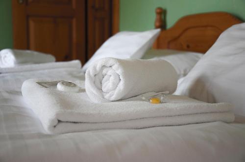 a pile of towels sitting on top of a bed at Penzion Diana in Teplice nad Bečvou
