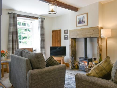 a living room with two chairs and a fireplace at Rose Cottage - Uk34067 in Grassington