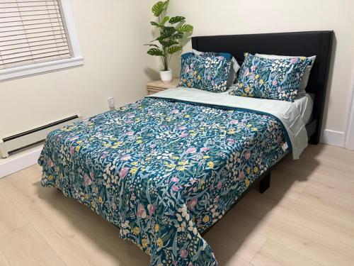 a bedroom with a bed with a floral bedspread and pillows at Cozy Home in Surrey