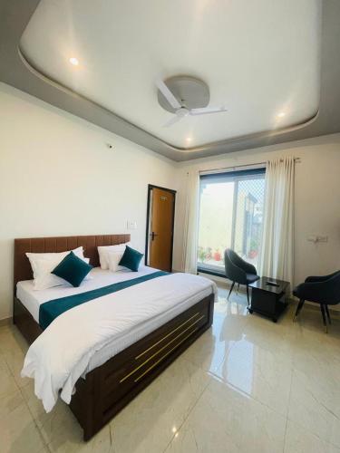 a bedroom with a large bed and a large window at villa Belmond with private pool in Udaipur