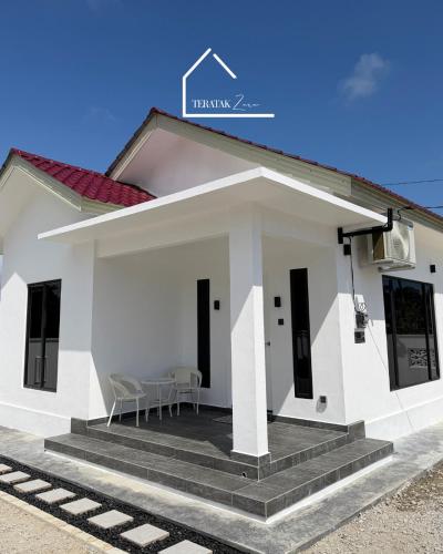 a white house with a porch and stairs at Teratak Zara in Kota Tinggi