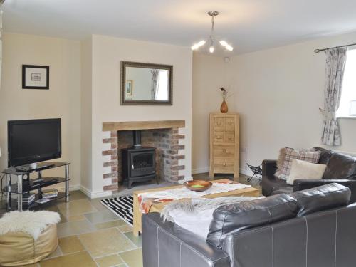 ein Wohnzimmer mit Sofa und Kamin in der Unterkunft Methodist Cottage in Tantobie