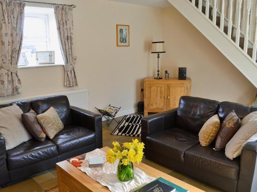 ein Wohnzimmer mit Sofa und Couchtisch in der Unterkunft Methodist Cottage in Tantobie