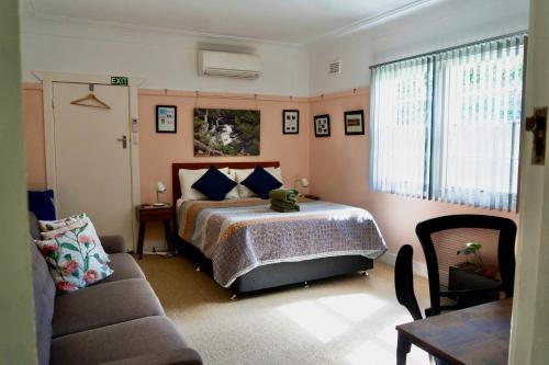 a bedroom with a bed and a couch at "Mansfield" Cottage Barrington - Quality Holidays for over 25 Years in Barrington