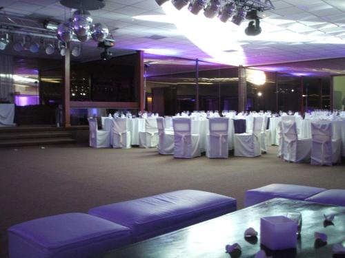 a banquet hall with white tables and white chairs at El Mirador Hotel & Spa in Colonia del Sacramento