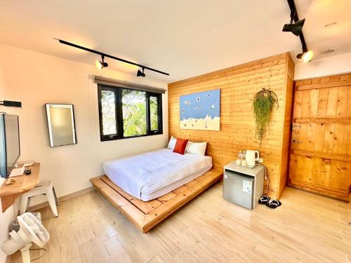 a bedroom with a bed on a wooden floor at 夏漾旅店Summer Delight 包棟民宿 in Nanwan
