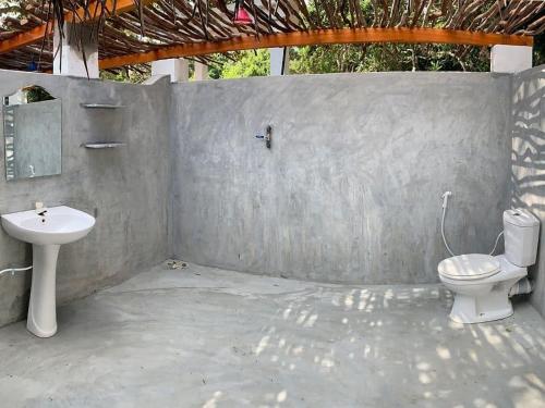 a bathroom with a toilet and a sink at Upali Beach Surf Resort in Nikawatawana
