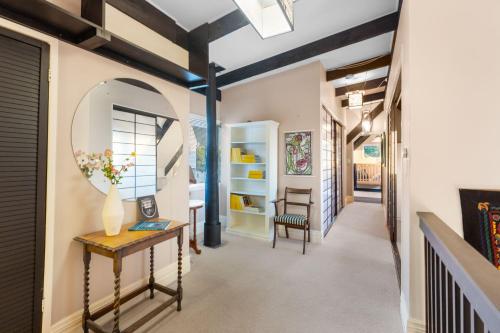 a hallway with a table and a mirror at Charming homely Cherry Villa B&B with a panorama view in Paraparaumu