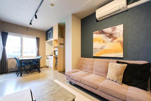 a living room with a couch and a table at UCHI Living Stay Sapporo Kikusui in Sapporo