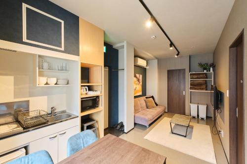 a kitchen and living room with a table and a couch at UCHI Living Stay Sapporo Kikusui in Sapporo