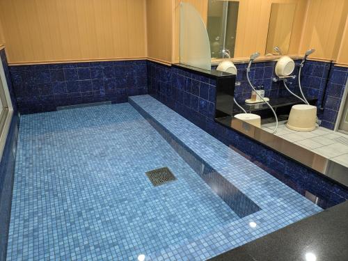 ein Badezimmer mit zwei Toiletten und einem blauen Fliesenboden in der Unterkunft HOTEL ERENOA in Nagoya