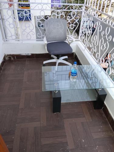 a chair sitting under a glass table with a bottle of water at PlatinumIN Guesthouse in kolkata