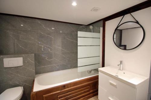 a bathroom with a sink and a tub and a toilet at La pommeraie in Château-Chervix