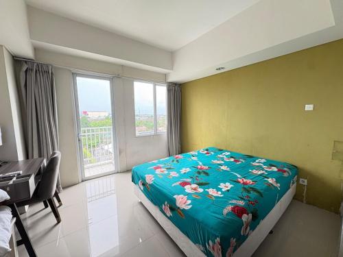a bedroom with a bed and a desk and a window at Studio Bogor Icon Apt wifi&pool in Kedunghalang