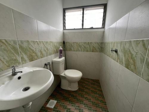 a bathroom with a sink and a toilet and a window at LAMAN SUZY Seri Iskandar in Seri Iskandar
