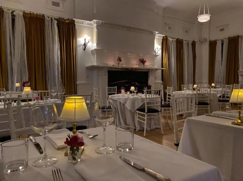 a room with white tables and chairs and a fireplace at The Robertson Hotel in Robertson