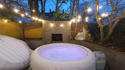a large bath tub with lights in a backyard at Hot Tub Emerald Escape - Private Garden & Free Parking in Cardiff