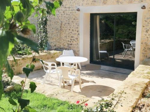 a white table and chairs on a patio at House And Playful Barn in Verrières