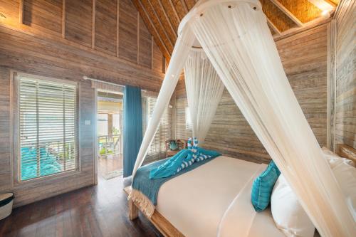 a bedroom with a bed with a canopy at Nusa View - Oceanfront Rentals in Nusa Lembongan