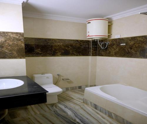 カトラにあるHotel Sahilの浴槽とトイレと洗面台のある浴室