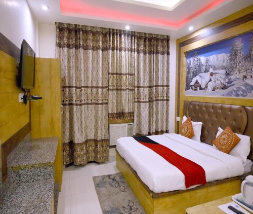 カトラにあるHotel Sahilのベッドとテレビのあるホテルの部屋