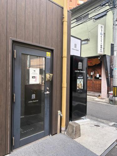 a door to a building with a sign on it at コインズホステル天神ペット宿泊可 in Fukuoka