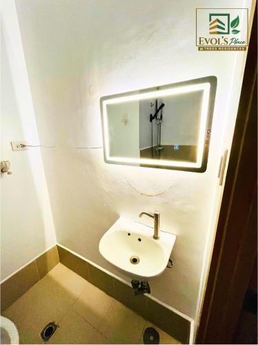 a bathroom with a sink and a mirror on the wall at Trees Residences Staycation 2 Bedroom in Manila