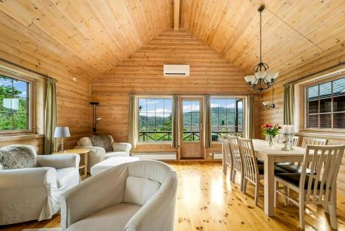 a living room with white furniture and wooden walls at Cabin With Jacuzzi And Stream In Krågeland in Kvinlog