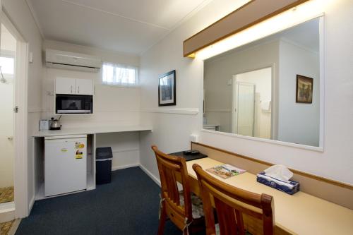 a waiting room with a table and a mirror at Mineral Sands Motel in Maryborough