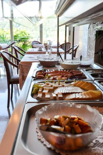 a long table with many plates of food on it at Hotel Garni Villa del Sole in Ponte Tresa