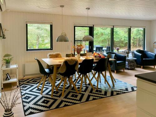 a dining room and living room with a table and chairs at Summer House 300 M From Beach in Hals