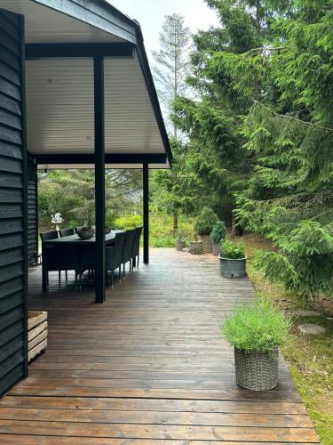 a wooden deck with a table and a dining room at Summer House 300 M From Beach in Hals