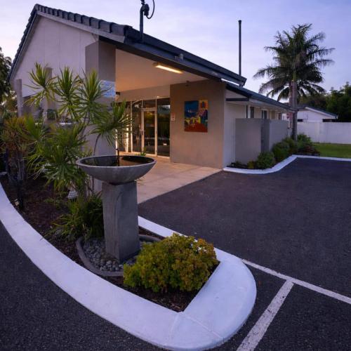 a building with a fountain in the middle of a parking lot at Busselton Gale Street Motel & Villas in Busselton