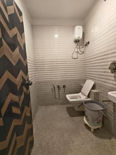 a bathroom with a toilet and a shower and a sink at Hotel Karnavati Motera Ahmedabad in Ahmedabad