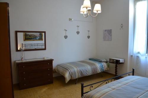 una camera con due letti, un comò e uno specchio di Casa Lia a Marina di Carrara