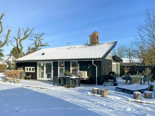 a small house in the snow in the yard at Architect-Designed Cottage By The Water in Middelfart