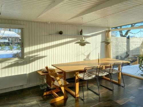 a dining room with a wooden table and chairs at Architect-Designed Cottage By The Water in Middelfart