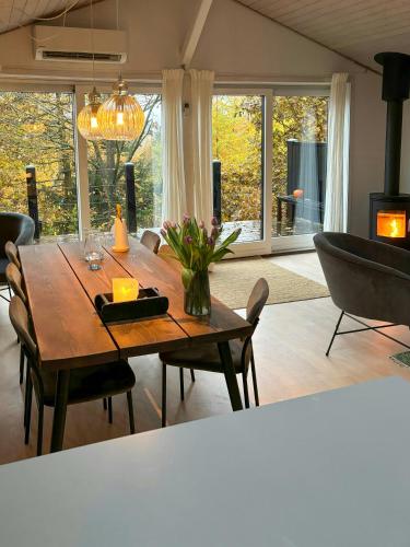 a living room with a wooden table and chairs at Forest Cabin Overlooking Bryrup Langsø in Silkeborg