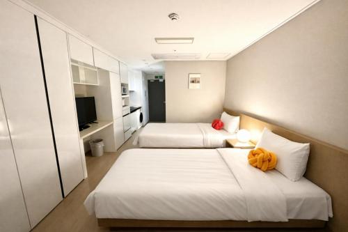 a hotel room with two beds and a television at 더 디셈버스테이 인 한라 in Taeam