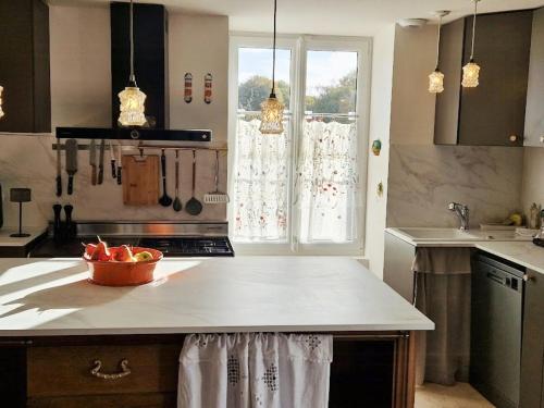 a kitchen with a counter with a bowl of fruit on it at House And Playful Barn in Verrières