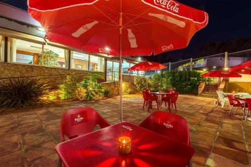 a restaurant with red chairs and a red umbrella at Hotel Sausa in Vilafreser