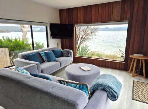 a living room with two couches and a large window at The Nebraska Retreat in Dennes Point