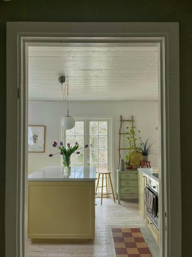 a kitchen with a counter and a table with flowers at Cosy House Surrounded By Nature in Diö